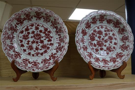 A pair of Chinese Ming-style underglaze copper red dishes, with wooden stands D.44cm